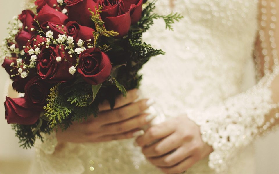 Novia de boda con ramo de rosas