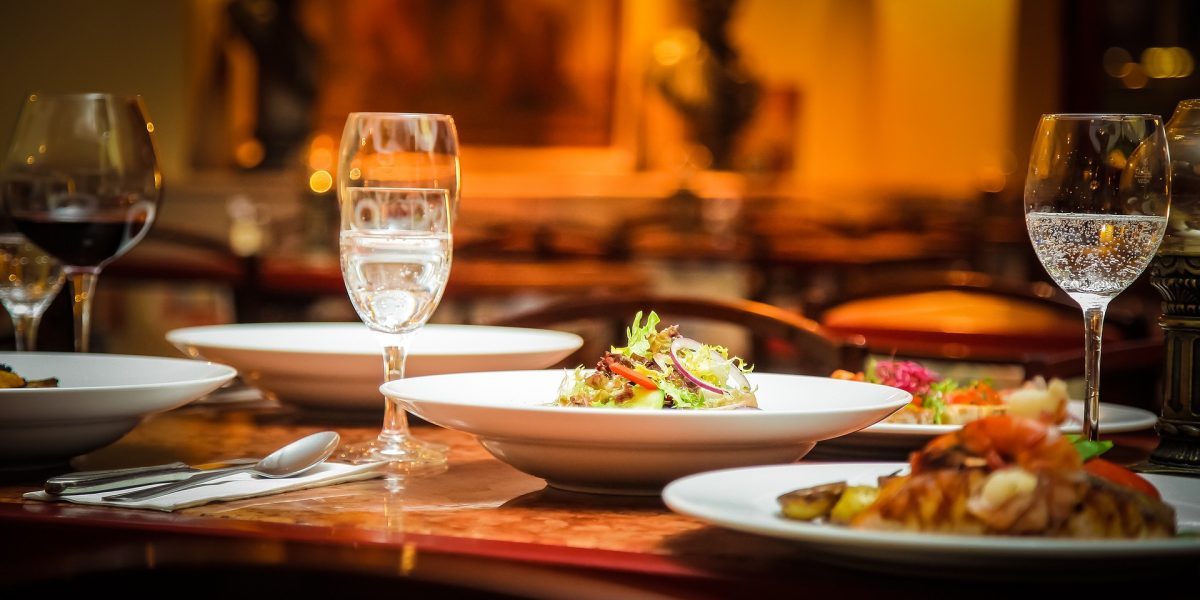 Plano de mesa de restaurante con platos de comida y copas