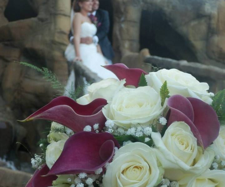 Pareja abrazada en el jardín de can montcad enfocando ramo