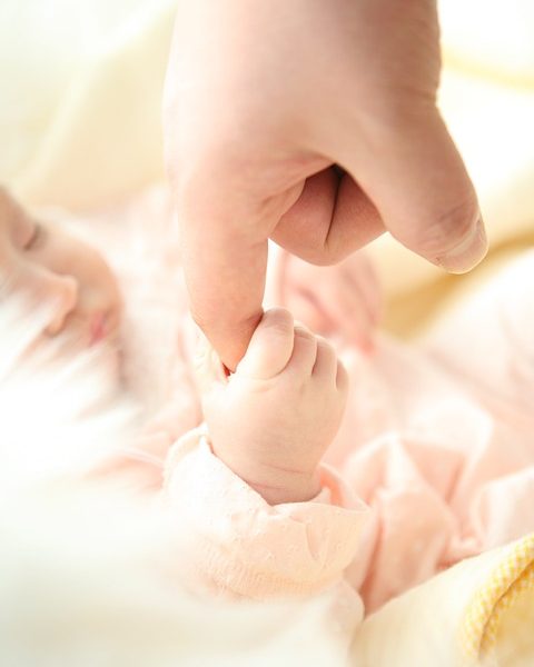 Bebé cogiendo el dedo de una persona