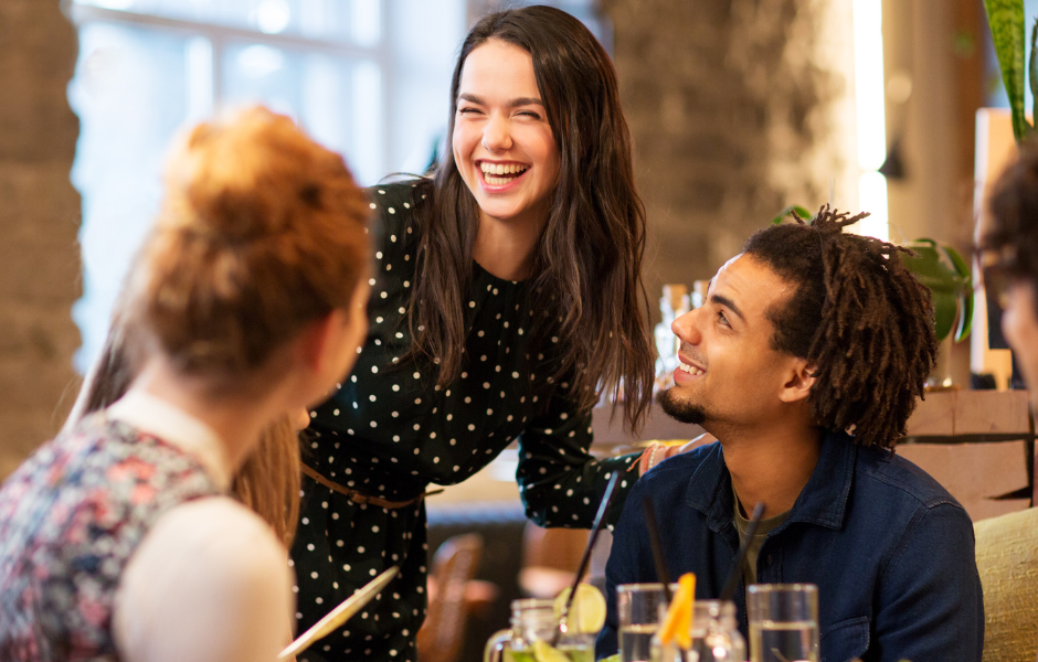 Chico sentado y chica de pie riendo